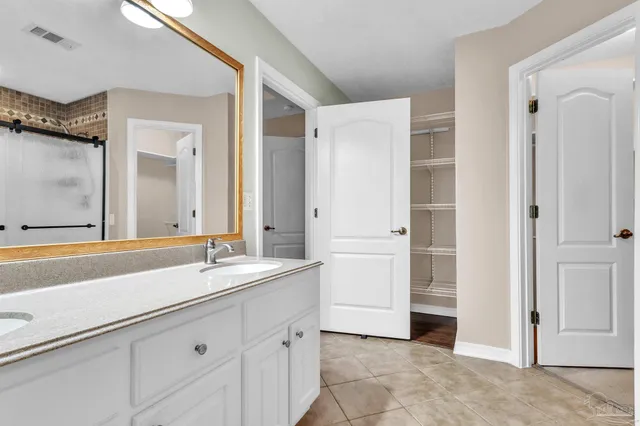 a spacious bathroom with a sink and a mirror
