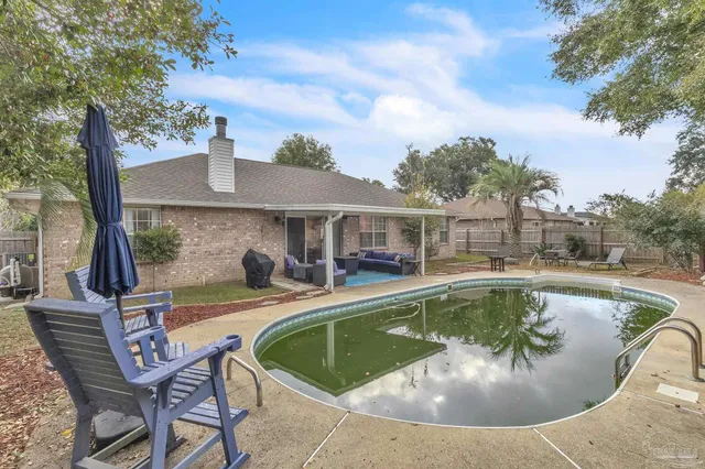 a view of a house with swimming pool and sitting area