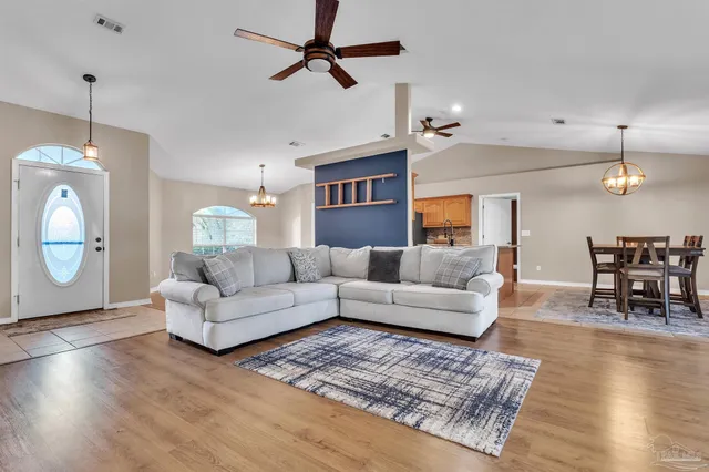 a living room with furniture a wooden floor and a chandelier