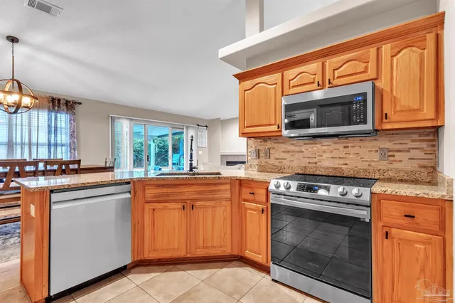 a kitchen with stainless steel appliances granite countertop a stove microwave and cabinets