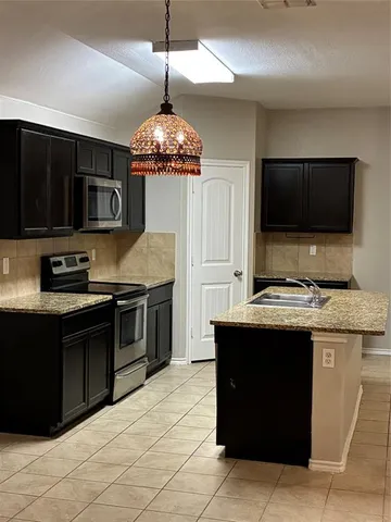 a kitchen with stainless steel appliances granite countertop a stove and a sink