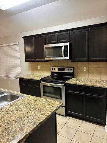 a kitchen with stainless steel appliances wooden cabinets and a stove