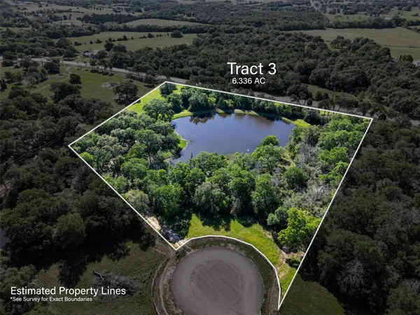 an aerial view of a house with a yard and lake view