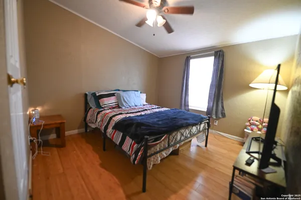 a spacious bedroom with a bed table closet and a lamp