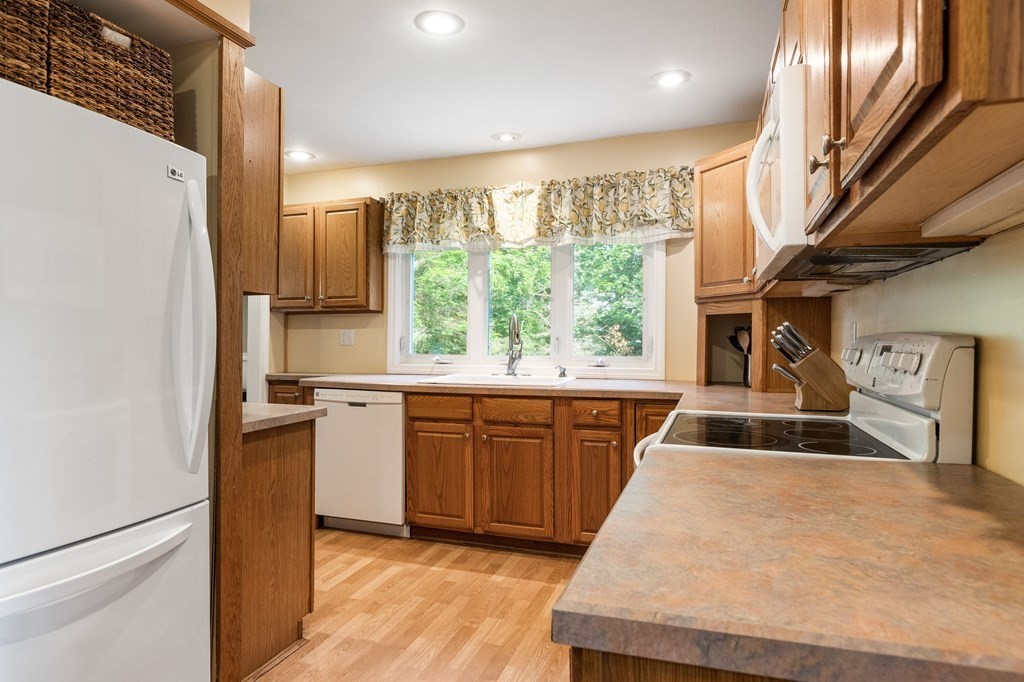 47 Victor Street Acushnet, MA 02743 - Photo 8 of 31 a kitchen with kitchen island granite countertop a stove a sink dishwasher and a refrigerator with wooden floor