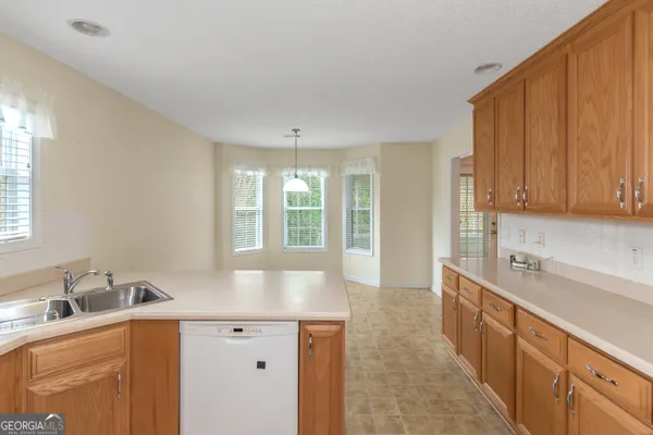 a large white kitchen with a sink