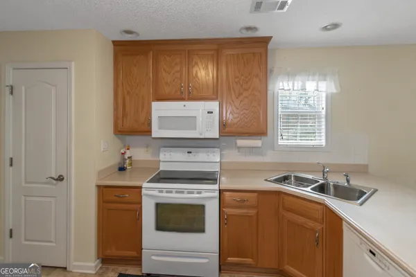 a kitchen with a sink stove and cabinets