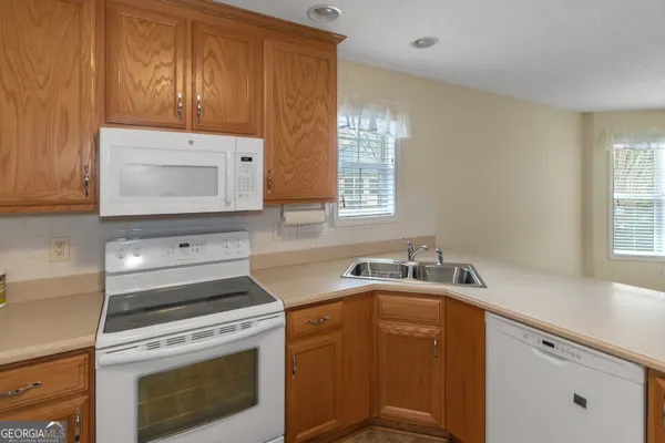 a kitchen with a sink stove and microwave
