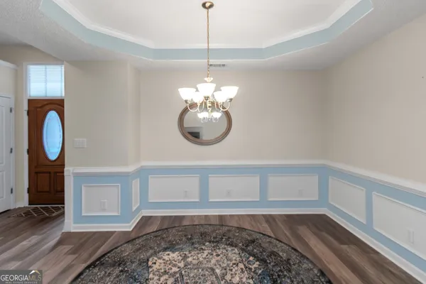 a view of a room with wooden floor and a chandelier