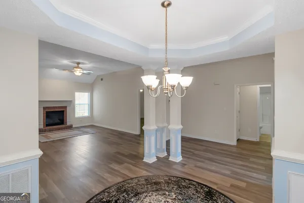 a view of a livingroom with a chandelier wooden floor and a chandelier