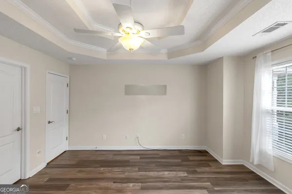 an empty room with wooden floor and windows