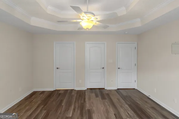 a view of an empty room and window and chandelier fan