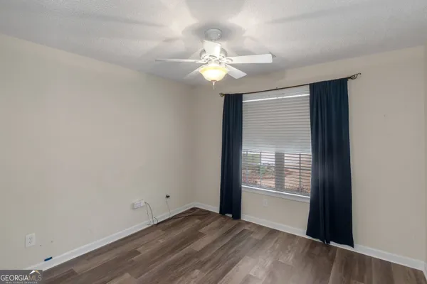 a view of wooden floor and a chandelier fan in a room