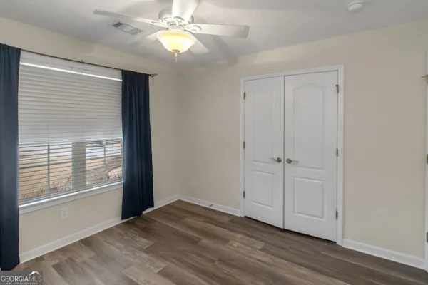a view of an empty room with window chandelier fan