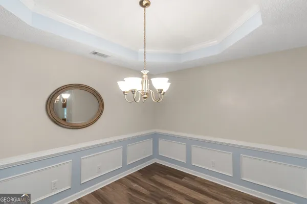 a view of a room with wooden floor and chandelier