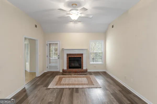 a view of an empty room with a fireplace and a window