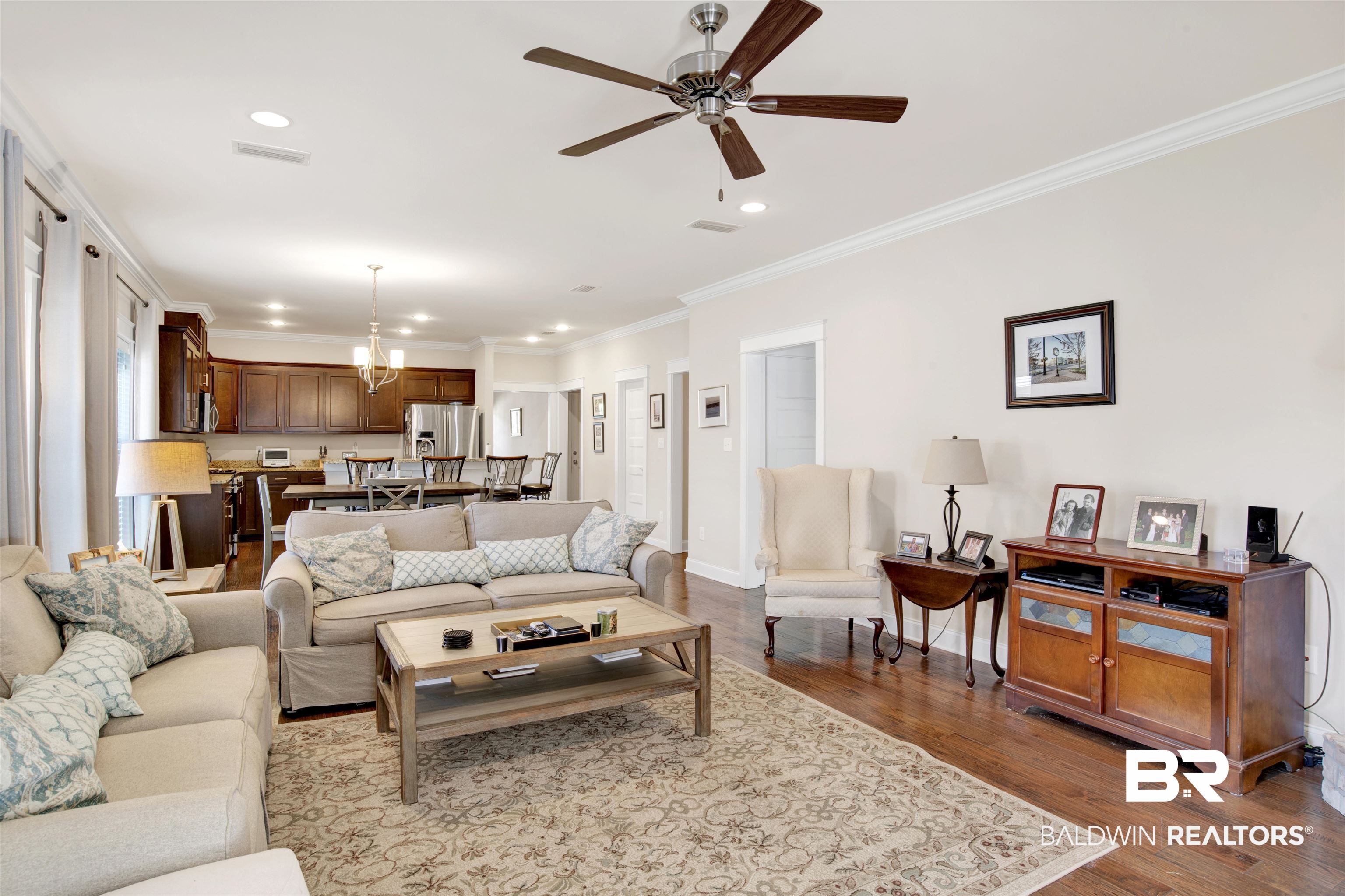 360 Scarlett Avenue Fairhope, AL 36532 - Photo 22 of 34 Living room with ceiling fan with notable chandelier, hardwood / wood-style floors, and crown molding