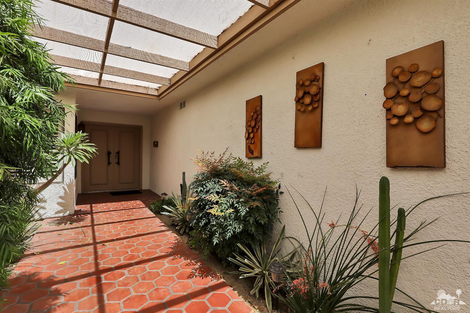 6 Palomas Drive Rancho Mirage, CA 92270 - Photo 2 of 20 a vase with flowers sitting on a floor in front of a door