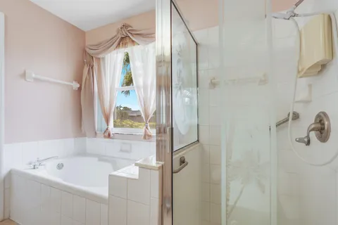 a bathroom with a tub shower and sink