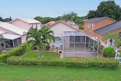 a front view of a house with a yard and potted plants