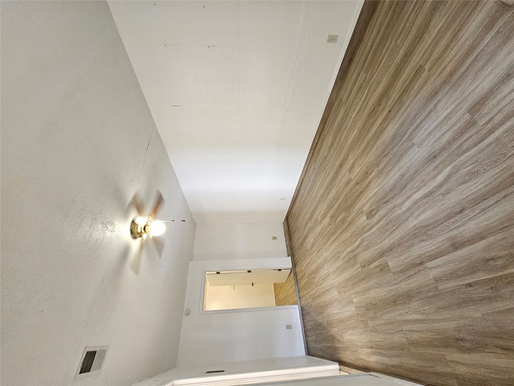 6000 Emerald Forest Drive, Unit A Austin, TX 78745 - Photo 17 of 19 an empty room with wooden floor and windows