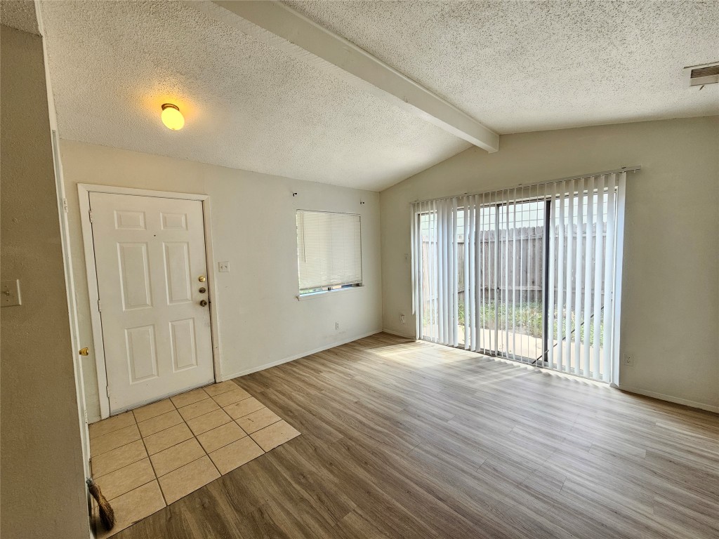 6000 Emerald Forest Drive, Unit A Austin, TX 78745 - Photo 3 of 19 a view of an empty room with wooden floor and a window