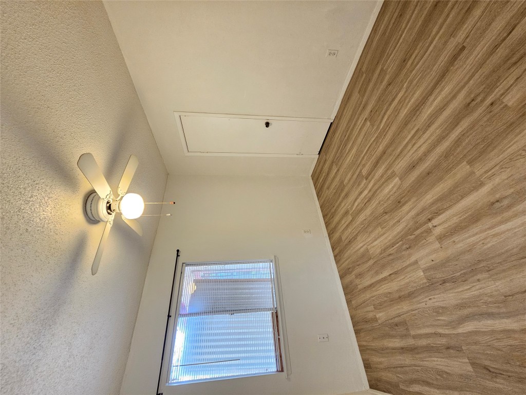 6000 Emerald Forest Drive, Unit A Austin, TX 78745 - Photo 8 of 19 an empty room with wooden floor fan and windows