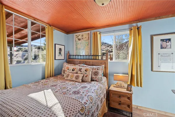 a bedroom with three beds and next to a window