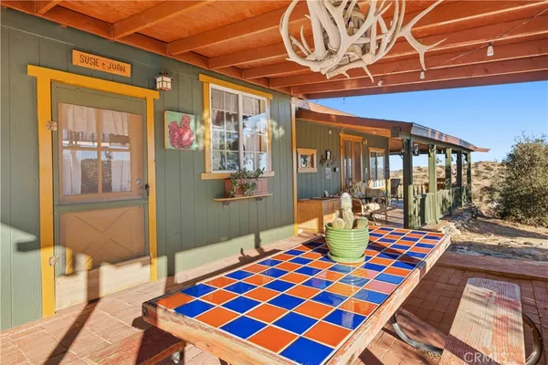 a view of a patio with table and chairs under an umbrella