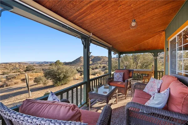 a balcony with wooden floor and furniture