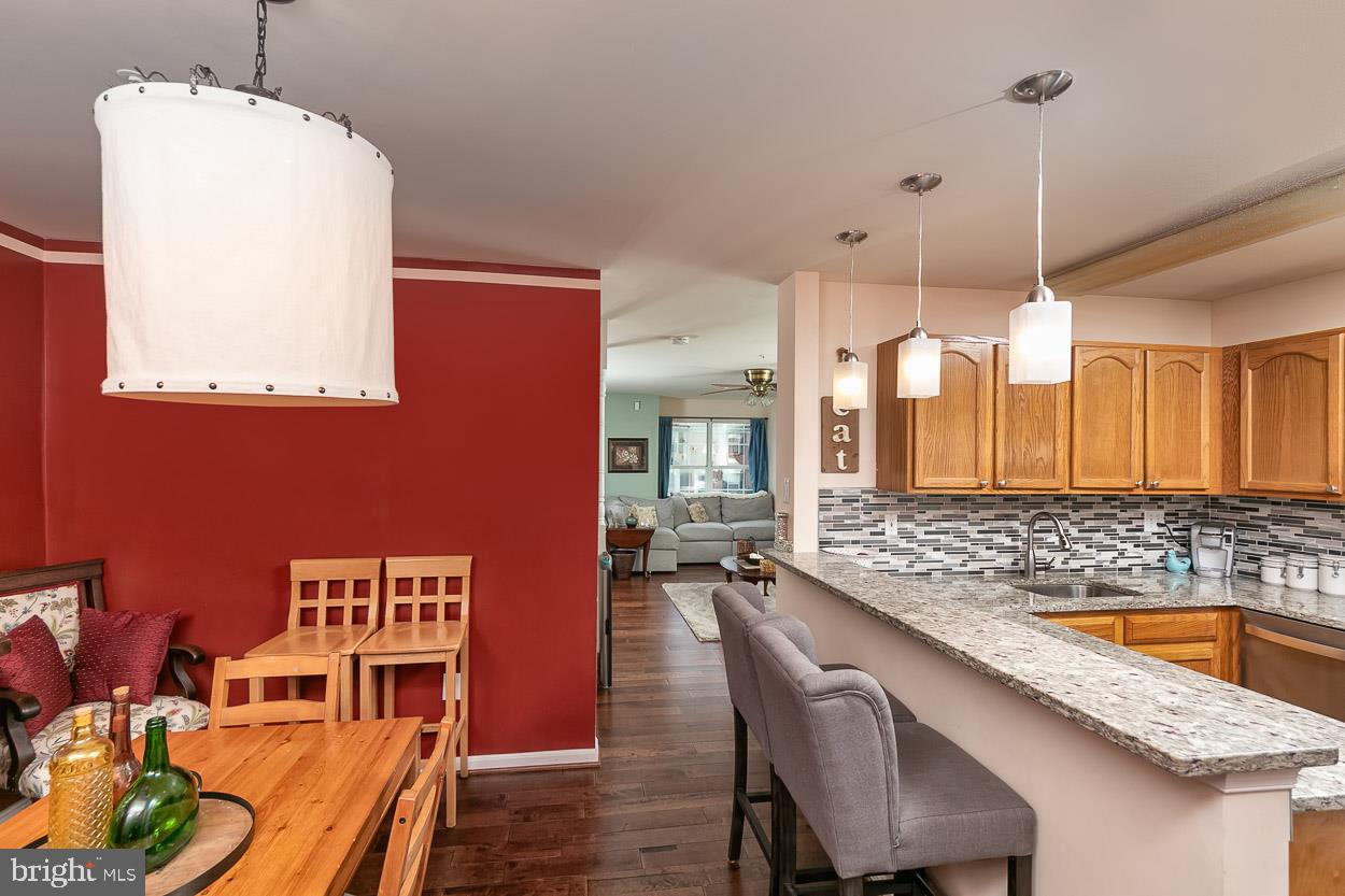 3504 Corn Stream Road Randallstown, MD 21133 - Photo 11 of 34 a dining room with stainless steel appliances kitchen island granite countertop furniture and a wooden floor