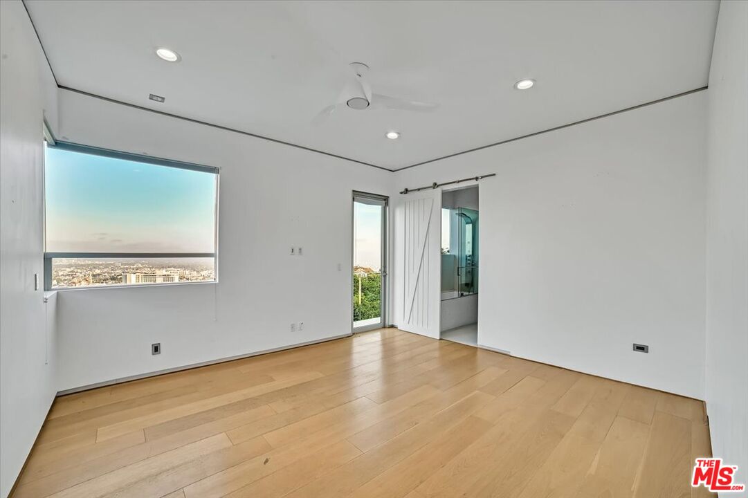 7044 Los Tilos Road Los Angeles, CA 90068 - Photo 18 of 58 a view of an empty room with wooden floor and a window