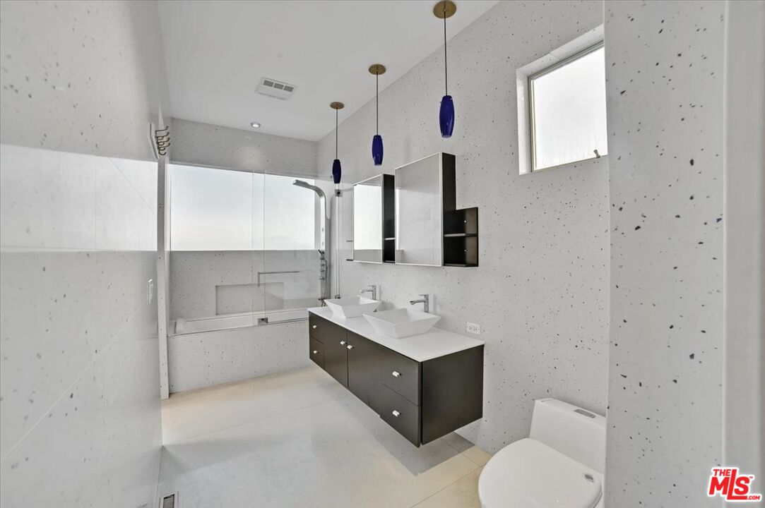 7044 Los Tilos Road Los Angeles, CA 90068 - Photo 21 of 58 a spacious bathroom with a double vanity sink toilet mirror and bathtub