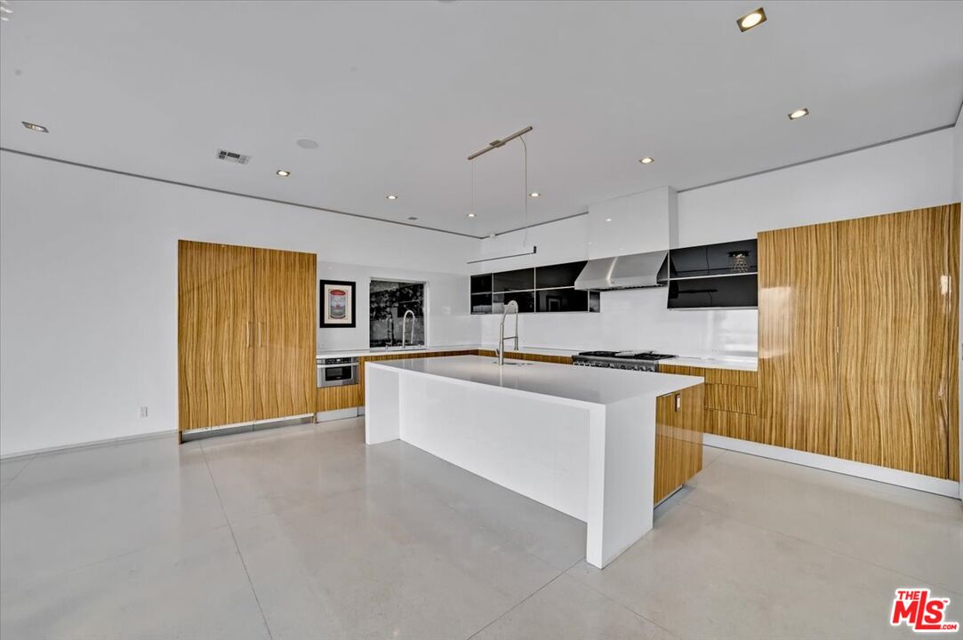 7044 Los Tilos Road Los Angeles, CA 90068 - Photo 32 of 58 a large kitchen with stainless steel appliances a large counter top a stove and a refrigerator