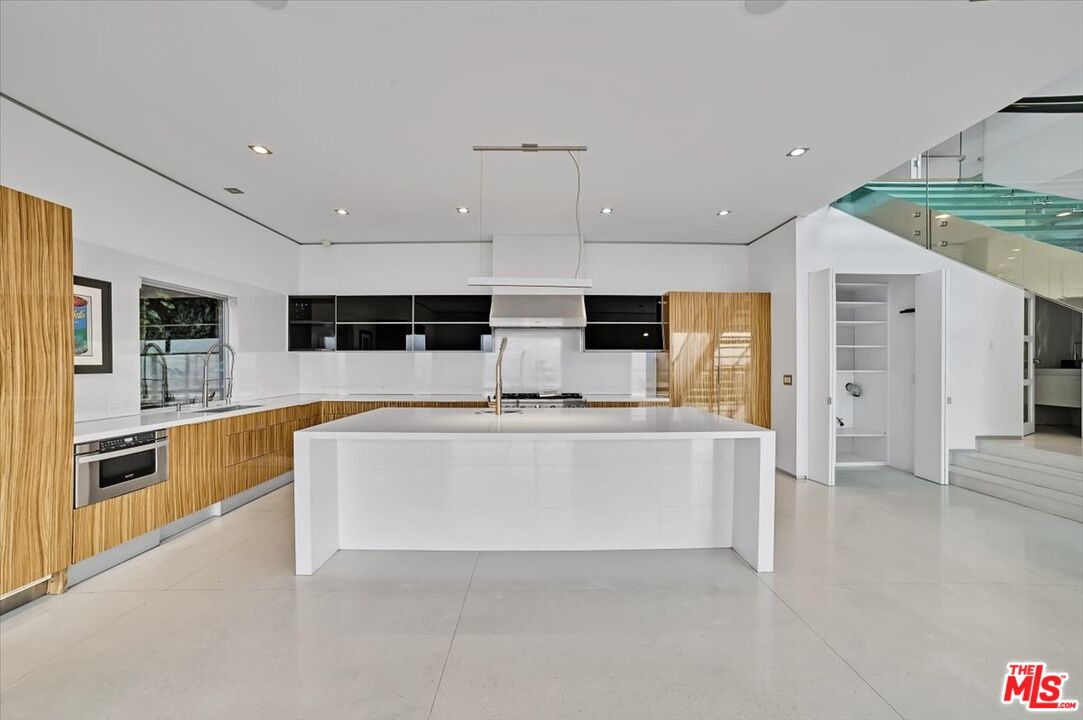 7044 Los Tilos Road Los Angeles, CA 90068 - Photo 33 of 58 a large white kitchen with stainless steel appliances kitchen island granite countertop a large counter top and a stove