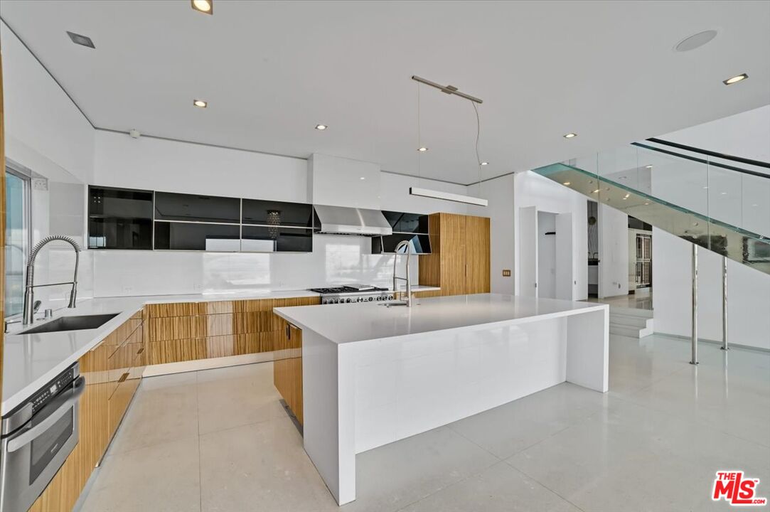 7044 Los Tilos Road Los Angeles, CA 90068 - Photo 34 of 58 a large kitchen with stainless steel appliances a large counter top a stove and a sink