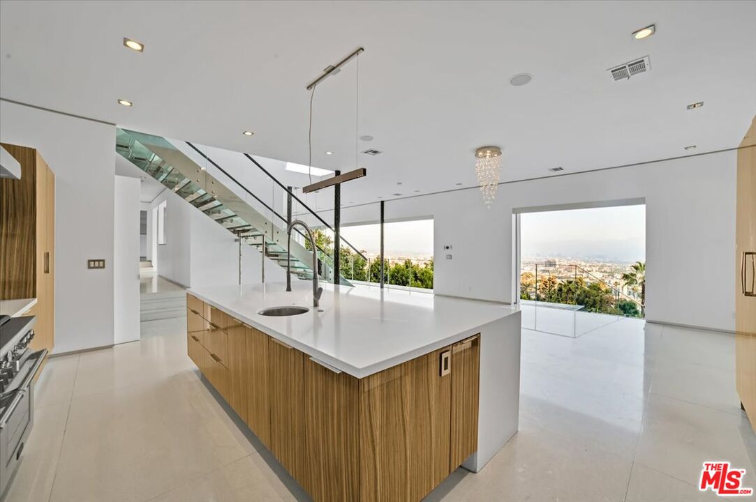 7044 Los Tilos Road Los Angeles, CA 90068 - Photo 35 of 58 a kitchen with stainless steel appliances granite countertop a sink and a wooden floor