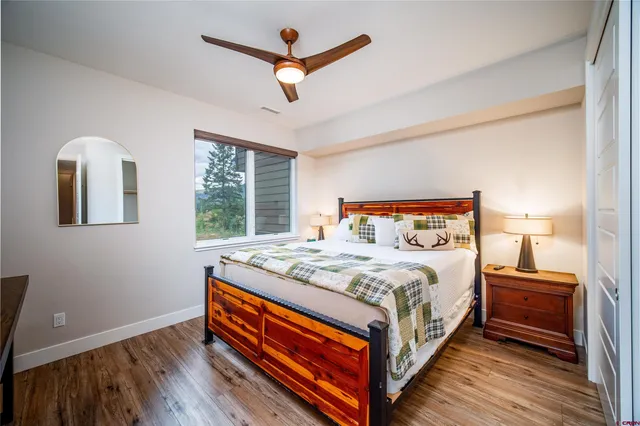 a bedroom with bed and wooden floor