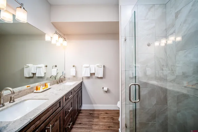 a spacious bathroom with double vanity and a shower
