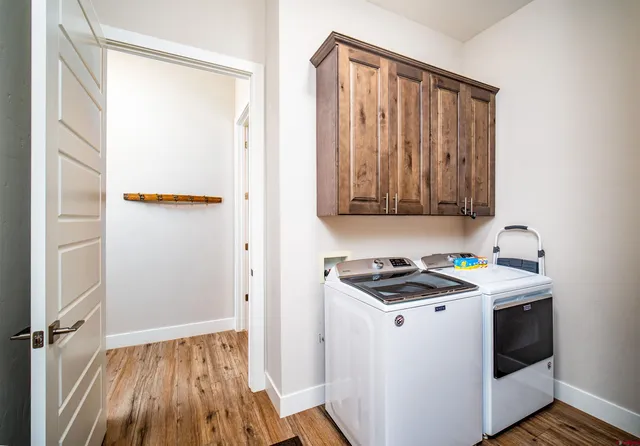 a utility room with wooden floor washer and dryer