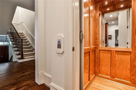 a view of a hallway with wooden floor and staircase