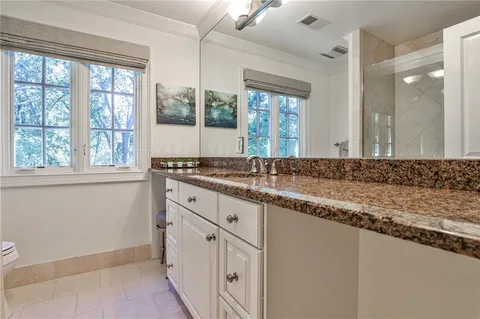 a bathroom with a granite countertop sink and a large mirror