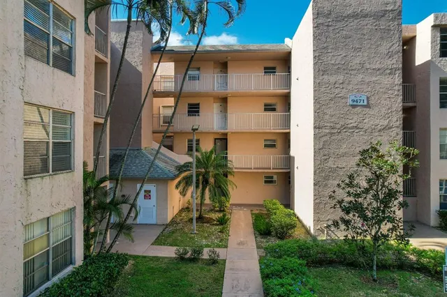 a front view of a house with a yard and potted plants