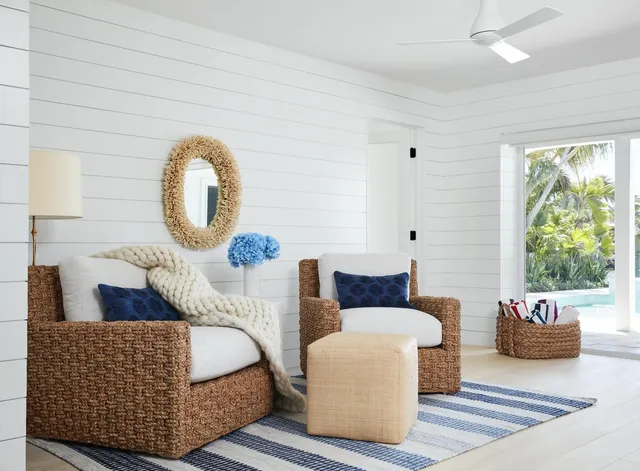 a white bed sitting in a bedroom next to a window