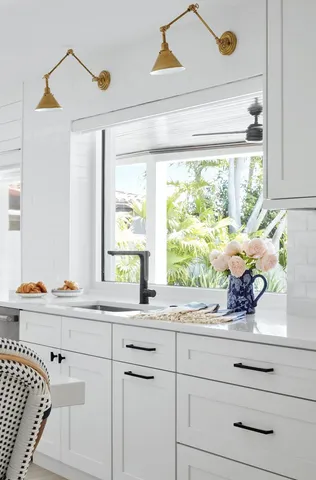 a sink with a window and cabinets