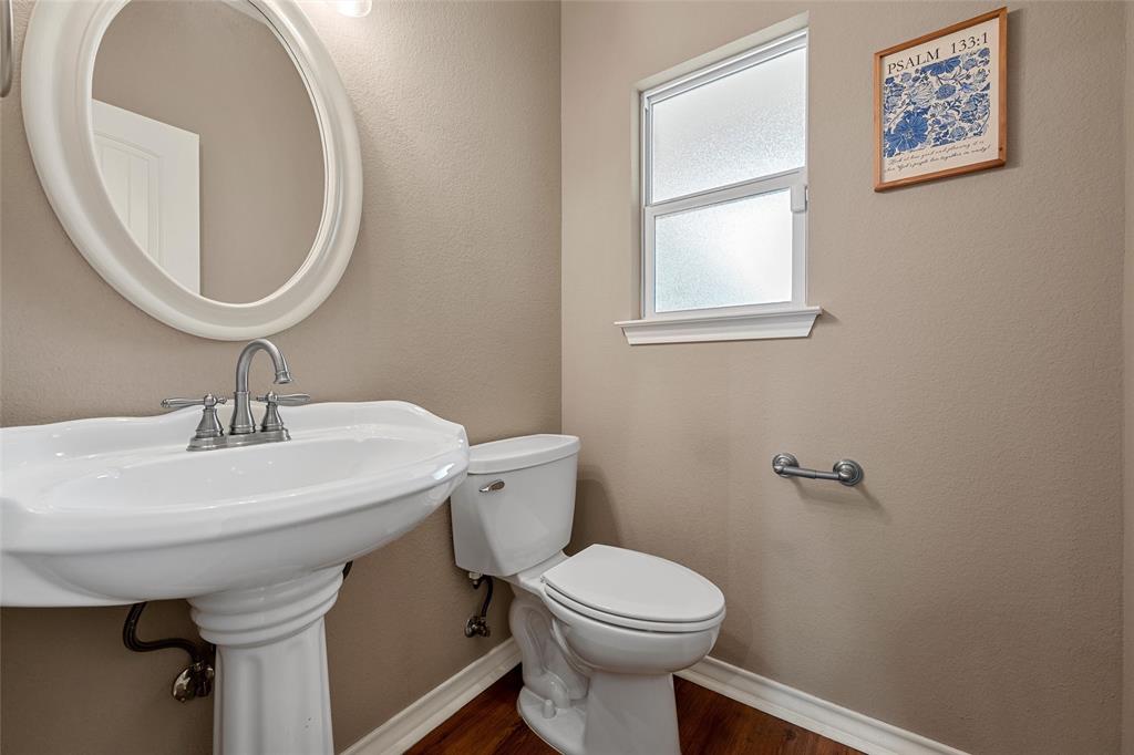 1117 Downsville Road Robinson, TX 76706 - Photo 22 of 40 Pedestal sink with chrome-finish fixtures, complemented by an oval wall mirror