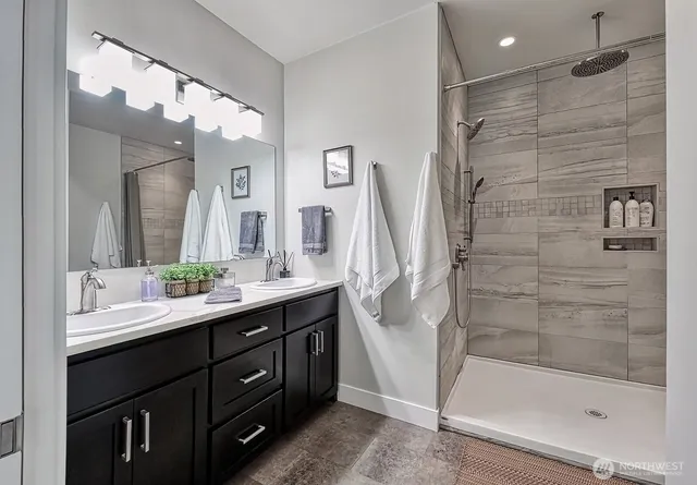 a bathroom with a double vanity sink mirror and shower