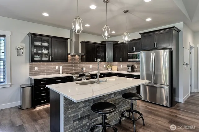 a kitchen with stainless steel appliances a refrigerator sink and stove