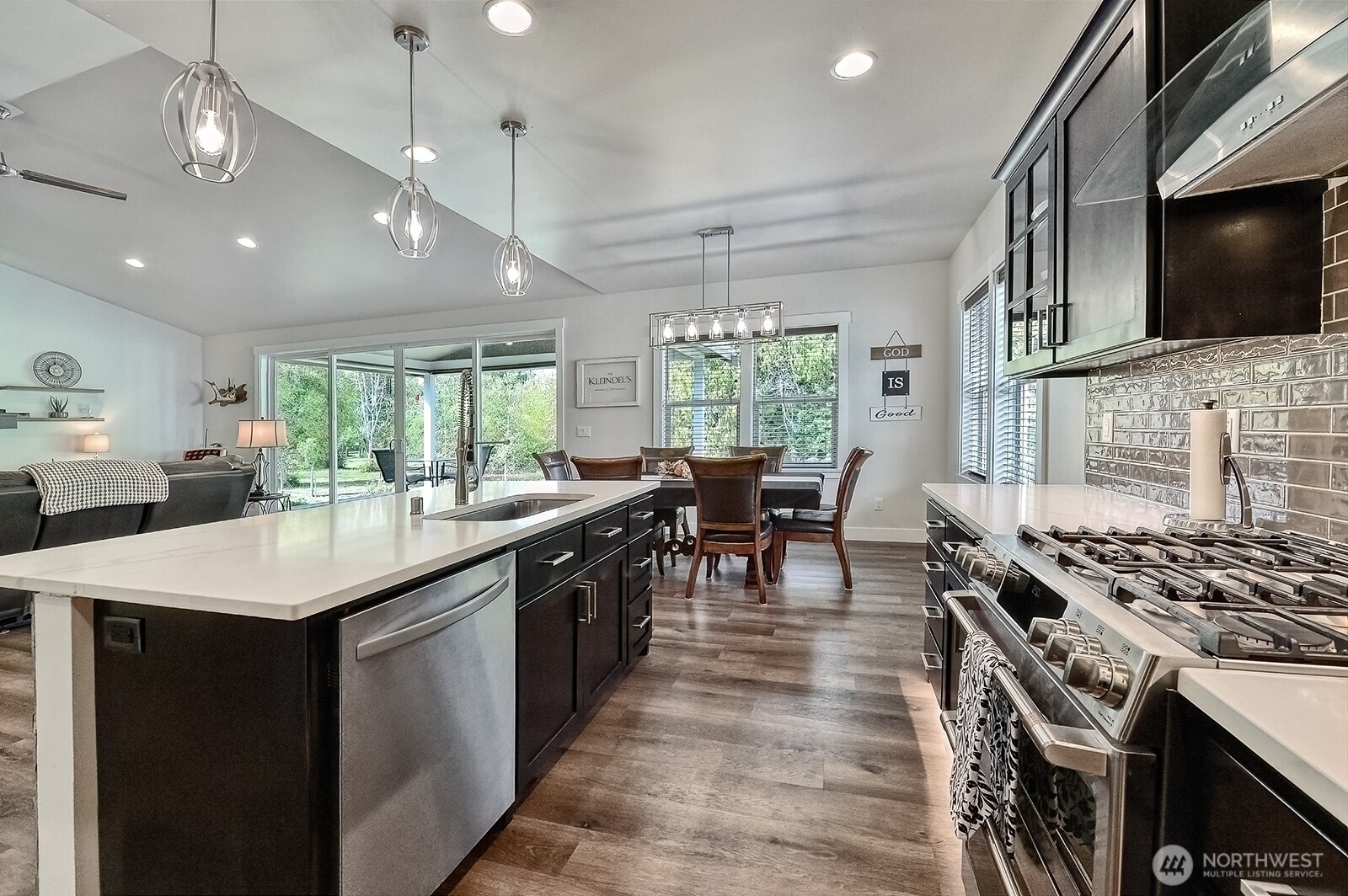 19443 Oakleaf Lane Sedro-Woolley, WA 98284 - Photo 9 of 40 a kitchen with stainless steel appliances granite countertop a stove top oven a sink dishwasher a dining table and chairs with wooden floor