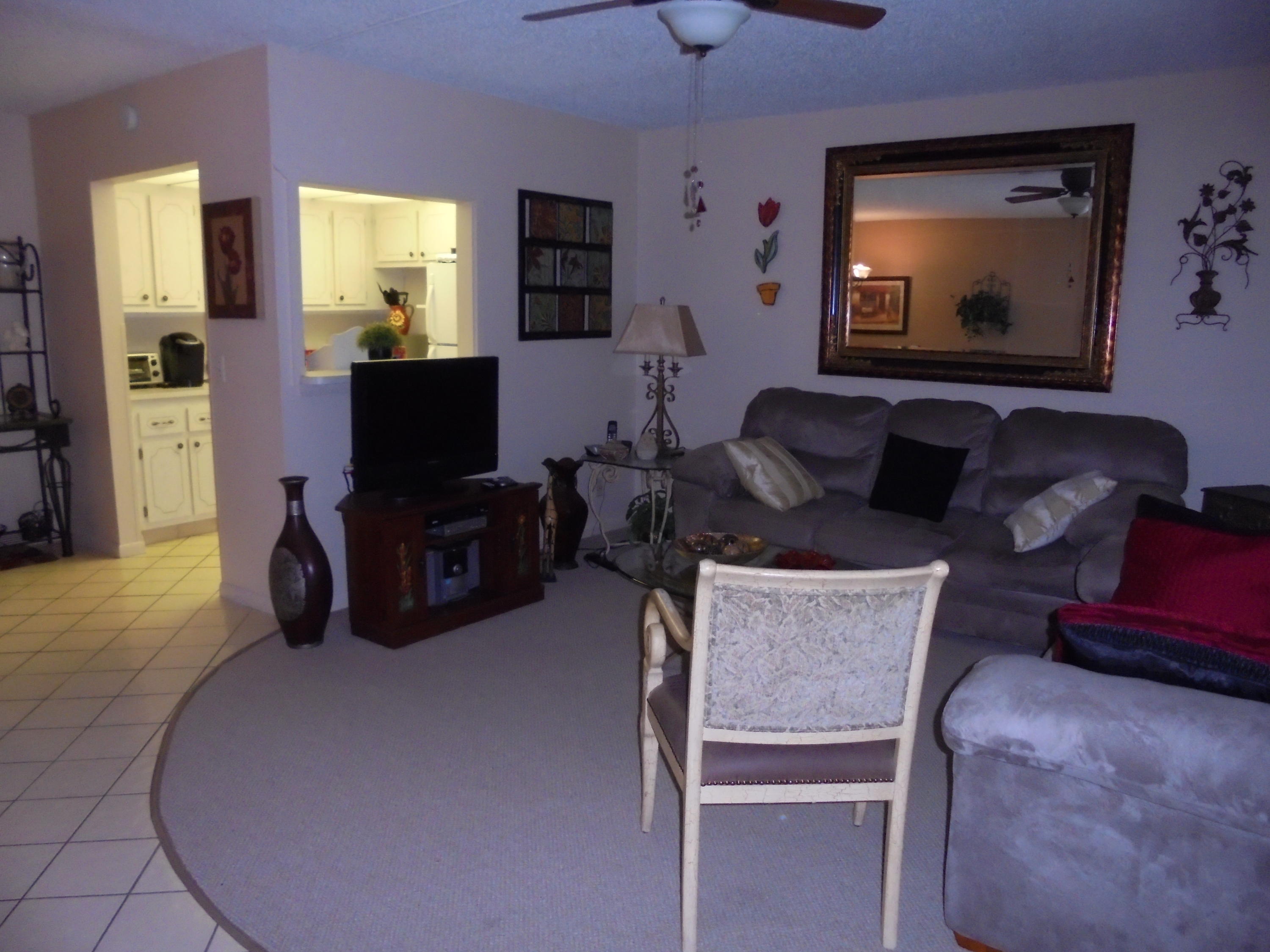 432 Mansfield K Boca Raton, FL 33434 - Photo 5 of 15 a living room with furniture a flat screen tv and a fireplace